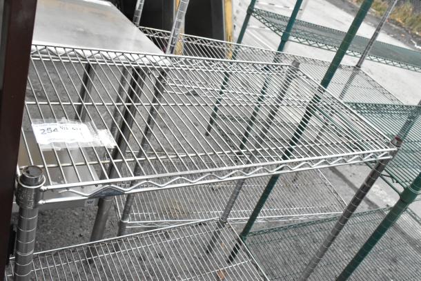 Chrome finish 2-tier wire shelving unit, visible MEGA METRO label, in used condition. Buyer must dismantle and arrange shipping.