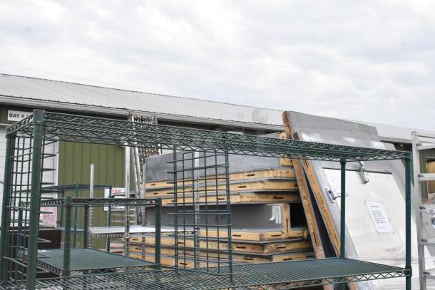 Green 4-tier wire shelving unit, sturdy construction, visible in outdoor storage. Buyer must dismantle; consider freight.