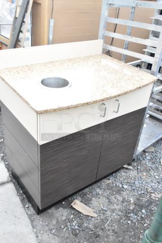 Trash can shell with granite-style top, circular trash deposit hole, and two doors. Features modern handles, good condition.