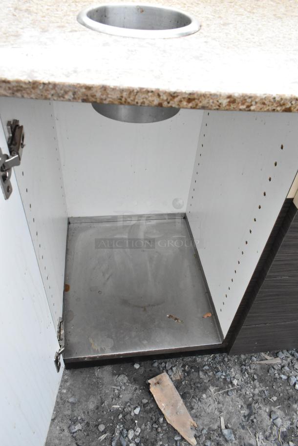 Trash can shell with granite top, round deposit hole, and two open doors. Metal interior base, some wear visible.