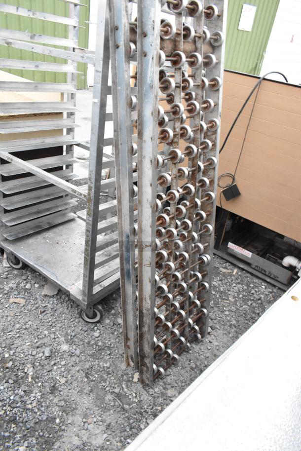 Two metal rolling conveyor belts in used condition, featuring rollers and rust marks, ideal for industrial use.