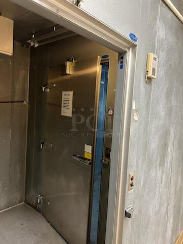 Norlake walk-in cooler and freezer combo, metal doors, interior shelving, control panel, signs and labels visible.