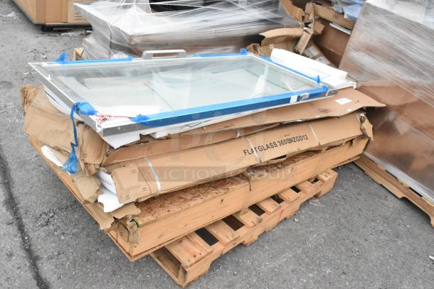 New scratch and dent sneeze guard on a pallet, wrapped and labeled "FLAT GLASS 360SNZGD12," in original packaging.