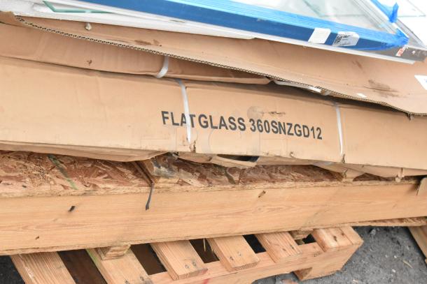 Packaging of scratch and dent sneeze guard and items, labeled "FLATGLASS 360SNZGD12," on wooden pallet.
