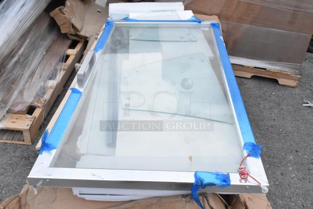 New sneeze guard with aluminum frame, slightly damaged, protective tape and wires attached, on pallet.