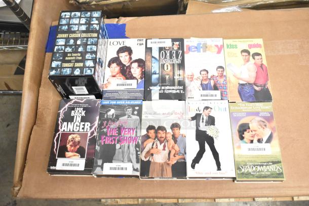 Collection of 18 VHS tapes including "Jeffrey," "Three Men and a Baby," and "Johnny Carson Collection" in good condition.
