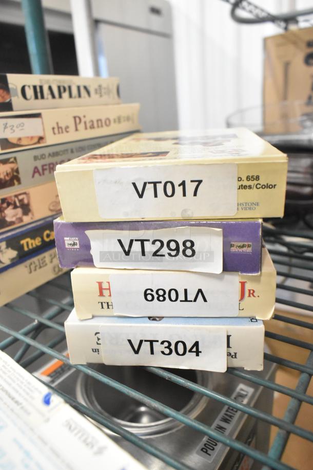 Stack of VHS tapes, including "Jeffrey" and "Three Men and a Baby," with visible labels VT017, VT298, VT680, VT304.