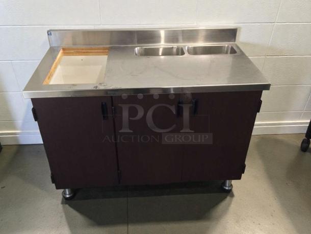 Custom stainless steel counter cabinet with dual sink and trash cutout, commercial grade, immaculate condition, inspected.