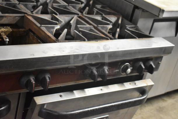 Southbend stainless steel 10-burner commercial gas range with 2 convection ovens, back splash, and over shelf. Missing 1 spider grate.