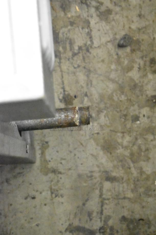 Rusty pipe extending from a stainless steel appliance, possibly the Garland SunFire convection oven gas connector.