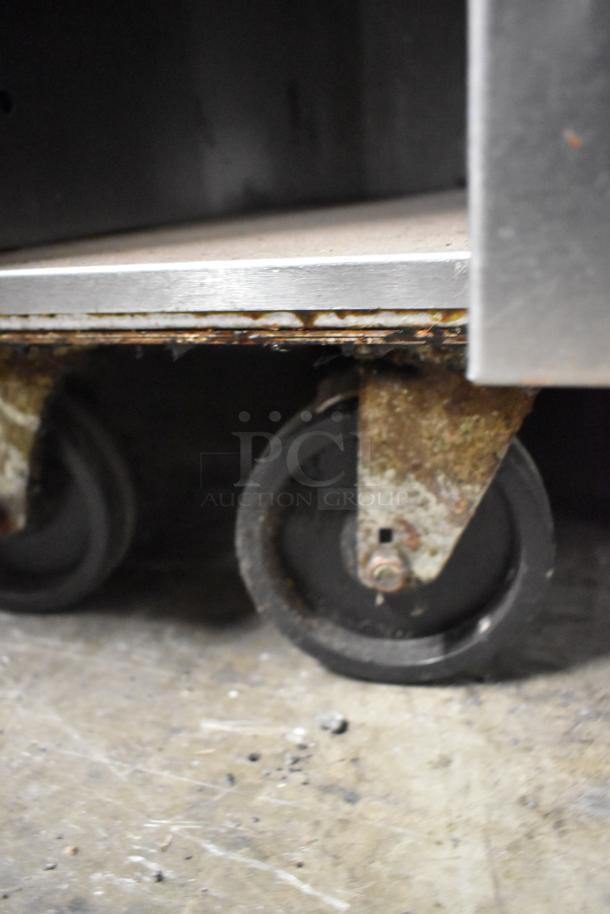 Vulcan 48C-SEFAAA stainless steel 8-burner range with convection oven, on worn commercial casters, showing rust.