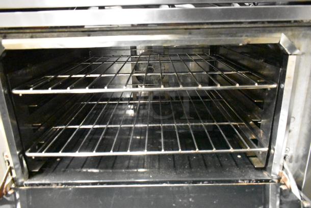 Vulcan 48C-SEFAAA stainless steel commercial range with 8 burners, convection oven, and back splash on casters.