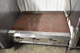 Ikon stainless steel commercial gas-powered griddle, countertop model, features three controls, in good condition.