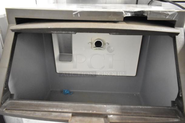 Manitowoc QF0406A stainless steel ice machine, 115 volts, 1 phase, interior view showing empty compartment, in good used condition.