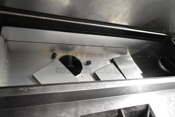 2019 True TPP-67 stainless steel pizza prep table interior. Some residue visible. 115 Volts, 1 Phase. Commercial casters.