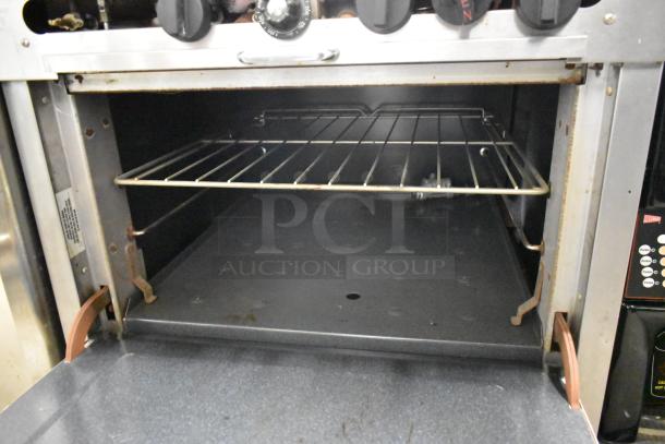 Southbend 1364D stainless steel commercial gas 4-burner range with oven, clean interior, rack, visible control panel.