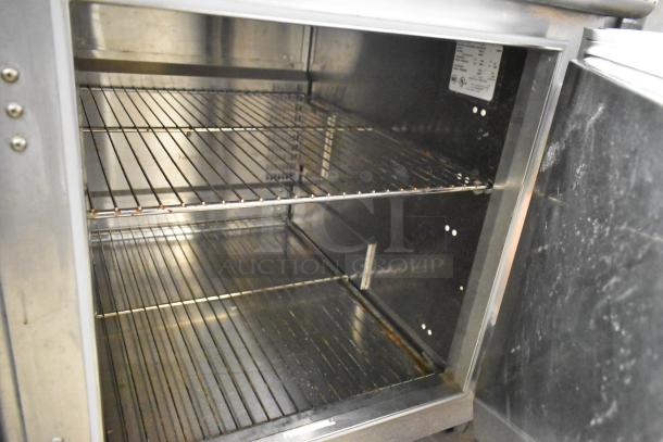 Traulsen UC2HT stainless steel 2-door undercounter cooler, 115 volts, clean interior, visible racks, light signs of use.