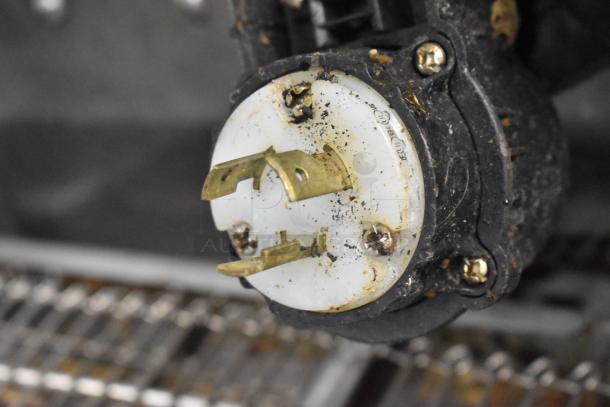 Close-up of a plug adapter component on a Middleby Marshall PS638G conveyor pizza oven. Displaying signs of use.