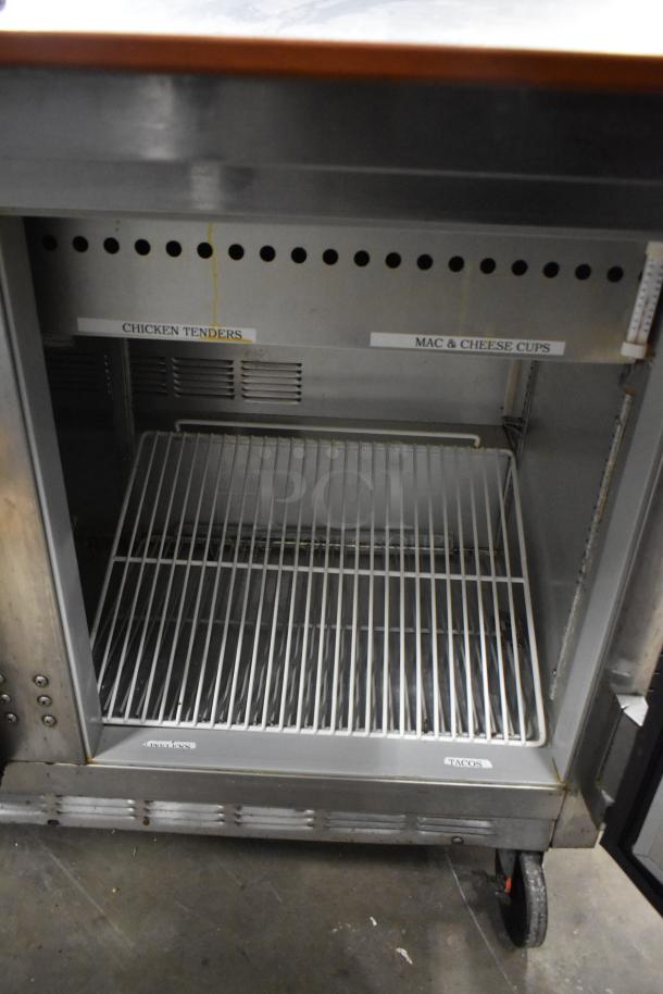 Beverage Air stainless steel sandwich salad prep table with bain marie mega top, on commercial casters. Visible labels for food items.