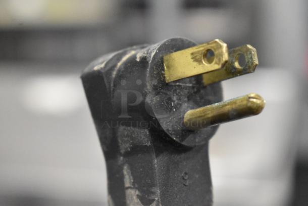 Close-up of a black and gold power plug for a Beverage Air commercial prep table, 115 volts, 1 phase.