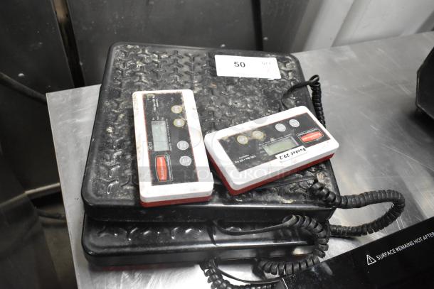 Two Rubbermaid 150-pound capacity scales, used, with digital displays and visible brand labels.