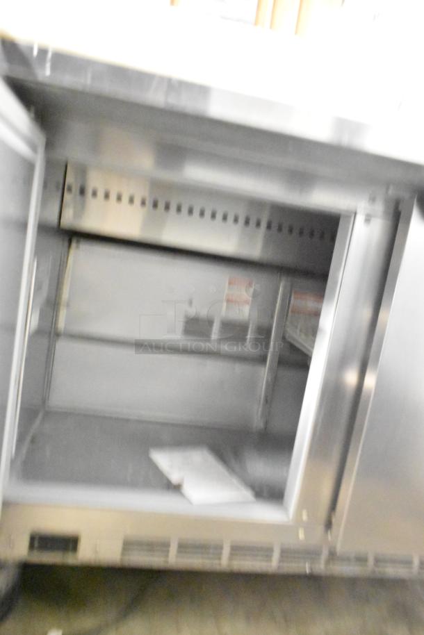 Beverage Air SPE48HC-12C stainless steel prep table, interior view, commercial casters, 115V, good condition.