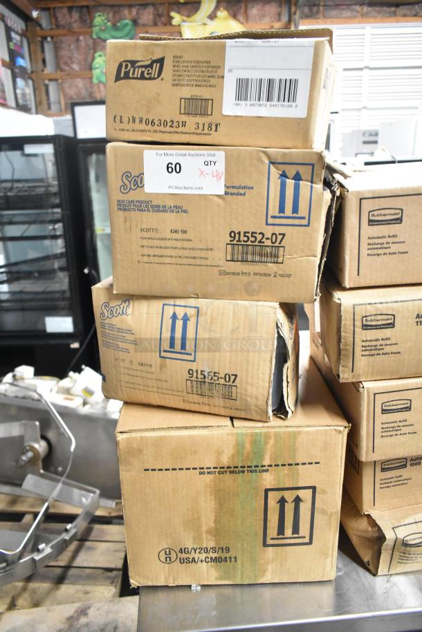 Four unopened boxes including Purell hand sanitizer dispenser, Scott foam skin cleanser, and Aqua Sparkle detergent.