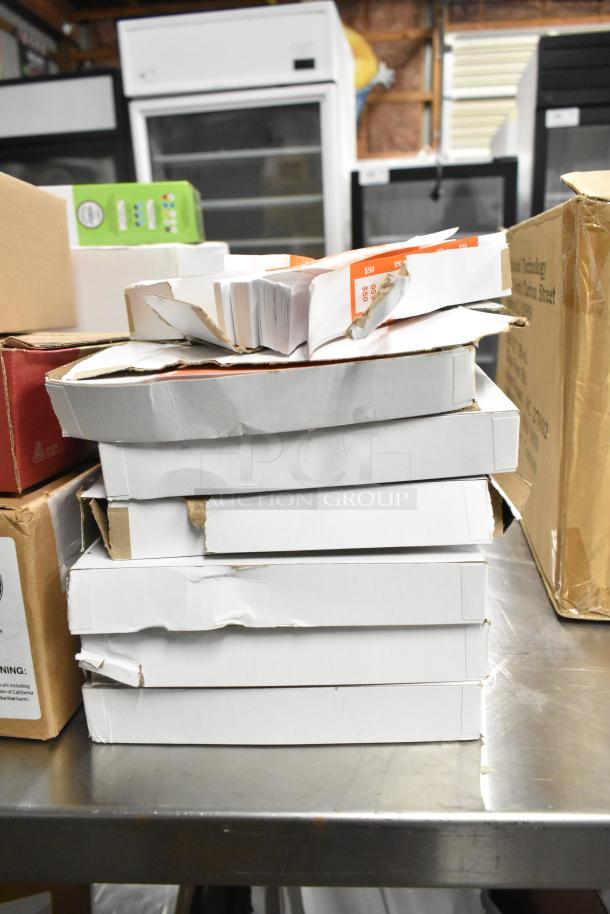 Stack of 10 brand new boxes on a table, including Nickel Rolls, Avery Dennison Monarch 1130 Labeler, 9078-3066 Printer Rolls.