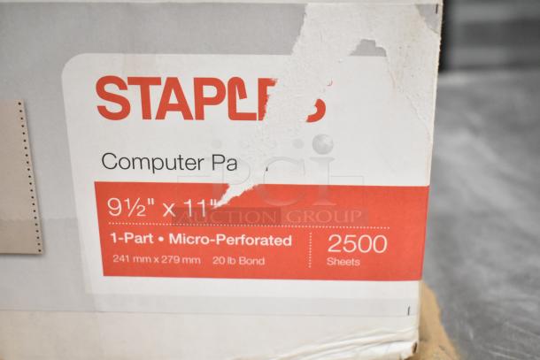 Two sealed boxes: one with a Dymo LabelManager, the other with Staples computer paper, 9.5"x11", 2500 sheets, 20 lb bond.