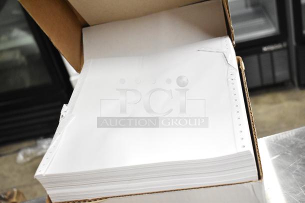 Brand new box of Staples computer paper with perforated edges, ready for use.