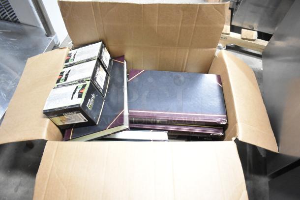 Cardboard box with 25 mixed items, including notebooks, Lexmark printer cartridges, and reams of copy paper.