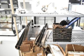 Tier lot of various items including metal legs for a convection oven and a gas hose. Items are displayed on metal racks. Condition varies.