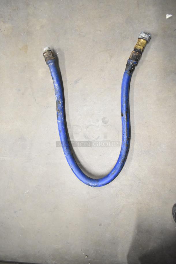 Blue gas hose with brass fittings, showing signs of wear. Part of a tier lot including metal legs for a convection oven.
