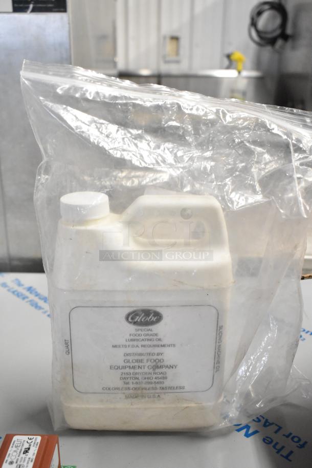 Plastic jug of Globe Food Grade Lubricating Oil, 1 quart. Label states FDA compliant, distributed by Globe Food Equipment Company.