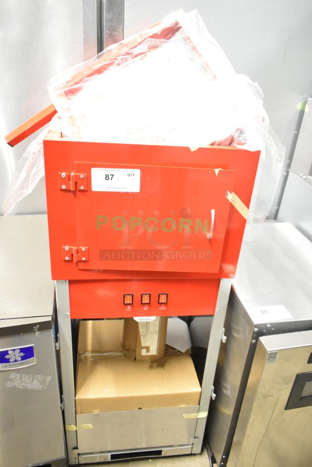 Brand new commercial popcorn machine and merchandising cart, red metal, scratch and dent, visible switches, item tag "87".