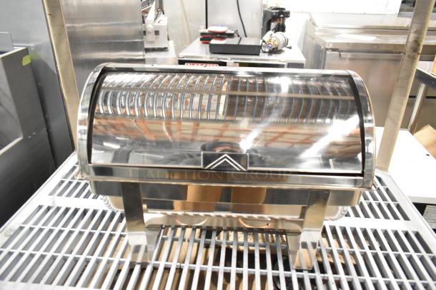 Stainless steel countertop chafing dish with roll-top lid, reflective finish, and sturdy legs in excellent condition.