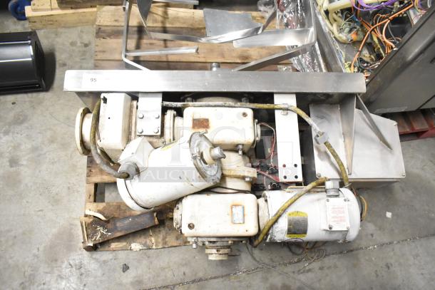 Lot of industrial equipment including a Baldor motor and assorted metal pieces on a pallet, condition used, markings visible.