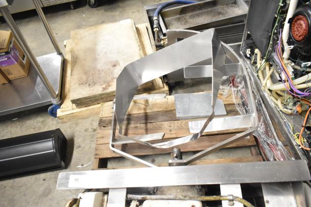 Alt text: Assorted metal pieces on a pallet including a Baldor motor, various shapes, and sizes, in used condition.