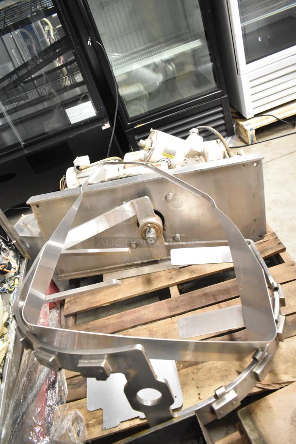 Baldor motor and metal pieces on a wooden pallet, showing signs of use. Ideal for industrial applications or parts.