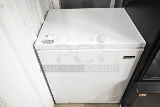 Magic Chef HMCF5W4 metal chest freezer with hinge lid, 115 volts, 1 phase. White exterior, branded badge visible.