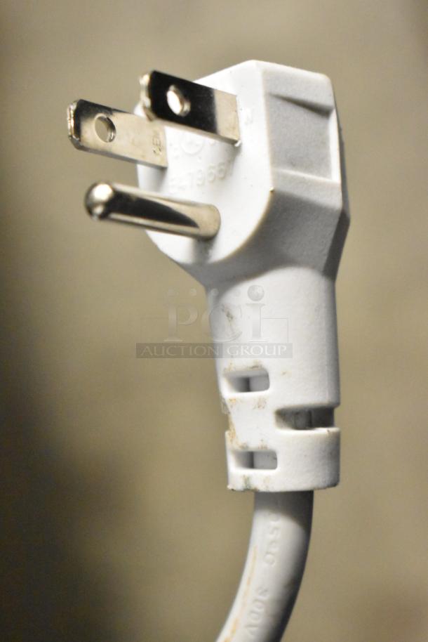 Close-up of a white power plug for a Magic Chef HMCF5W4 chest freezer. Plug shows standard prongs and slight wear.