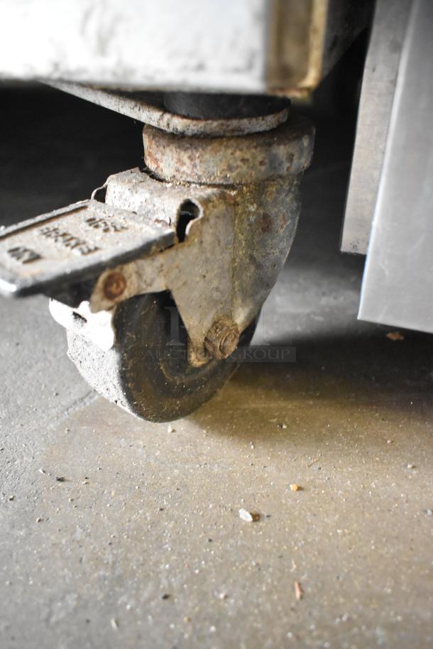 Arctic Air F22CW7 freezer caster with visible wear and rust, indicating mobility and use.