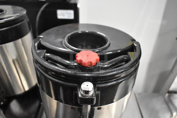 Three Fetco metal countertop beverage dispensers with black lids and red knobs, in good condition.