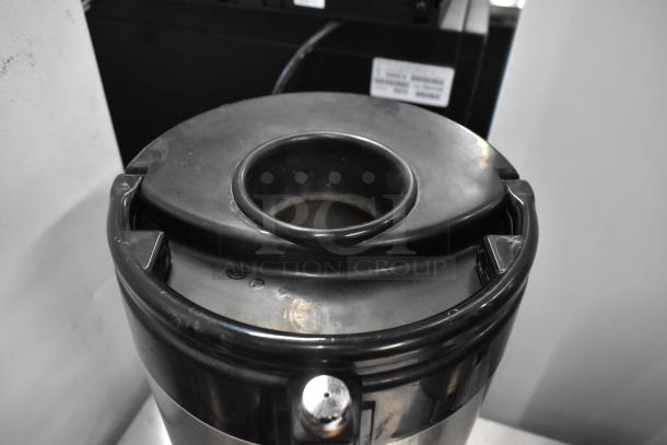 3 Fetco metal countertop beverage holder dispensers, black and silver, in good condition. Features secure lids and sturdy handles.