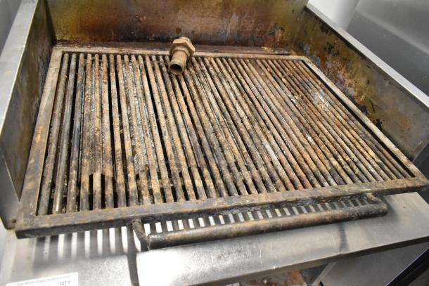 MagiKitch'n stainless steel commercial charbroiler grill, natural gas powered, with visible grill wear and rust.