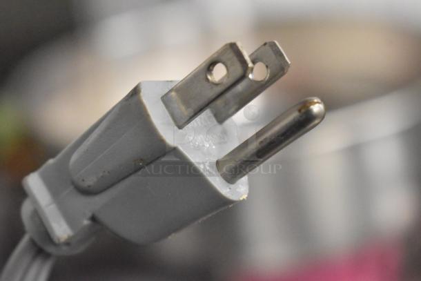 Close-up of a standard two-prong plug for the Sharp ER-A420 countertop cash register, displaying slight wear.