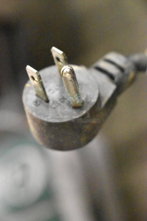 Close-up of a power plug for a 2019 Delfield 406P-STAR2 cooler, showing three prongs. Plug condition appears used.