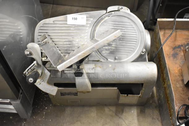 Hobart 1712 metal commercial countertop meat slicer, 115 volts, shows wear, includes labels and control switches.