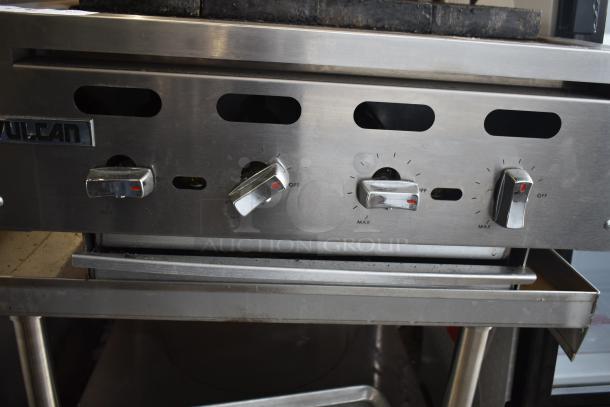 Vulcan VACB25-101 stainless steel charbroiler grill, 68,000 BTU, natural gas, on equipment stand. Control knobs and logo visible.
