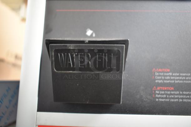 BRAND NEW Hatco Flav-r-savor Heated Holding Cabinet. Scratch and dent. Close-up of "WATER FILL" label and warning text.